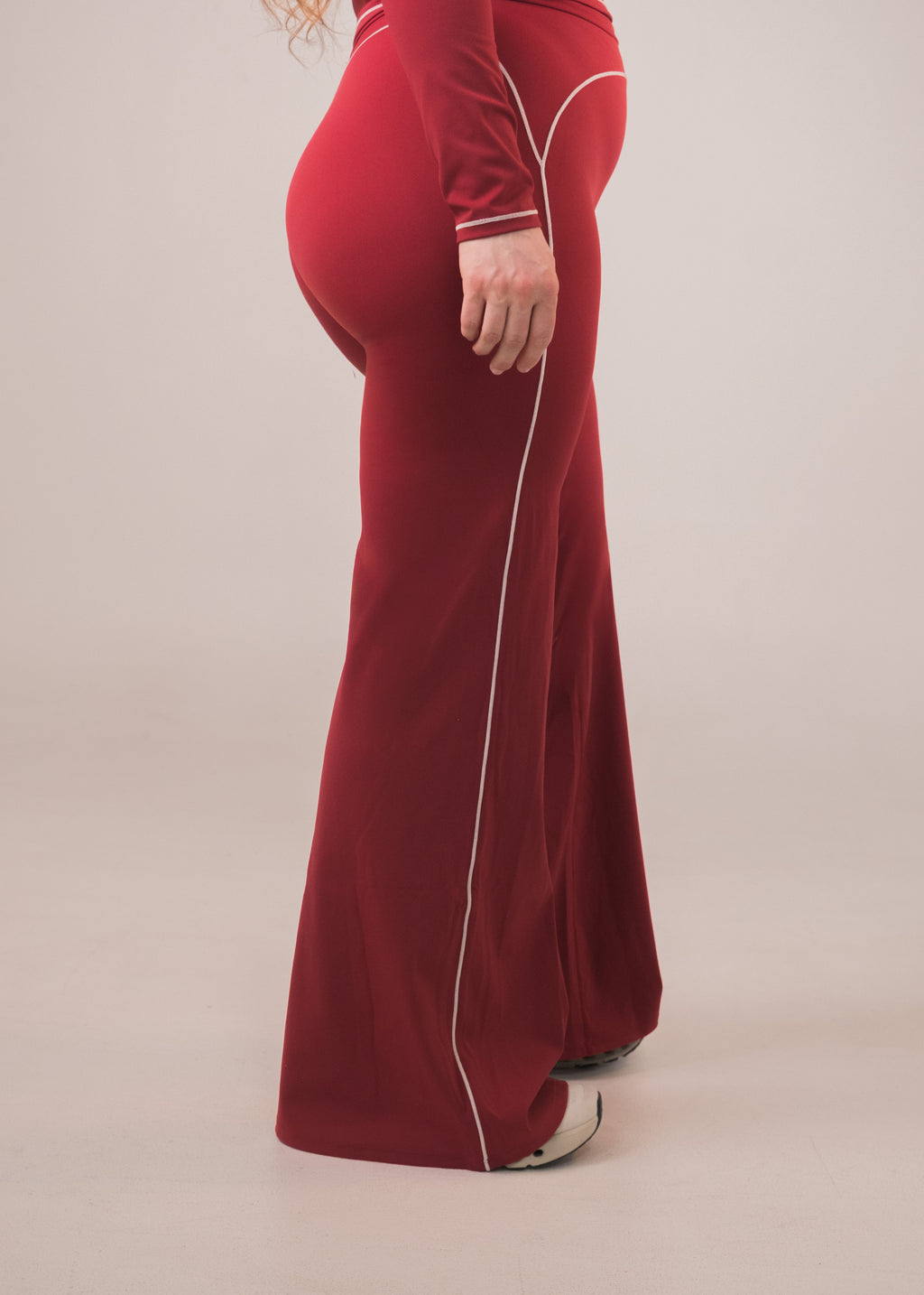 Red velvet outfit with white piping on a beige background