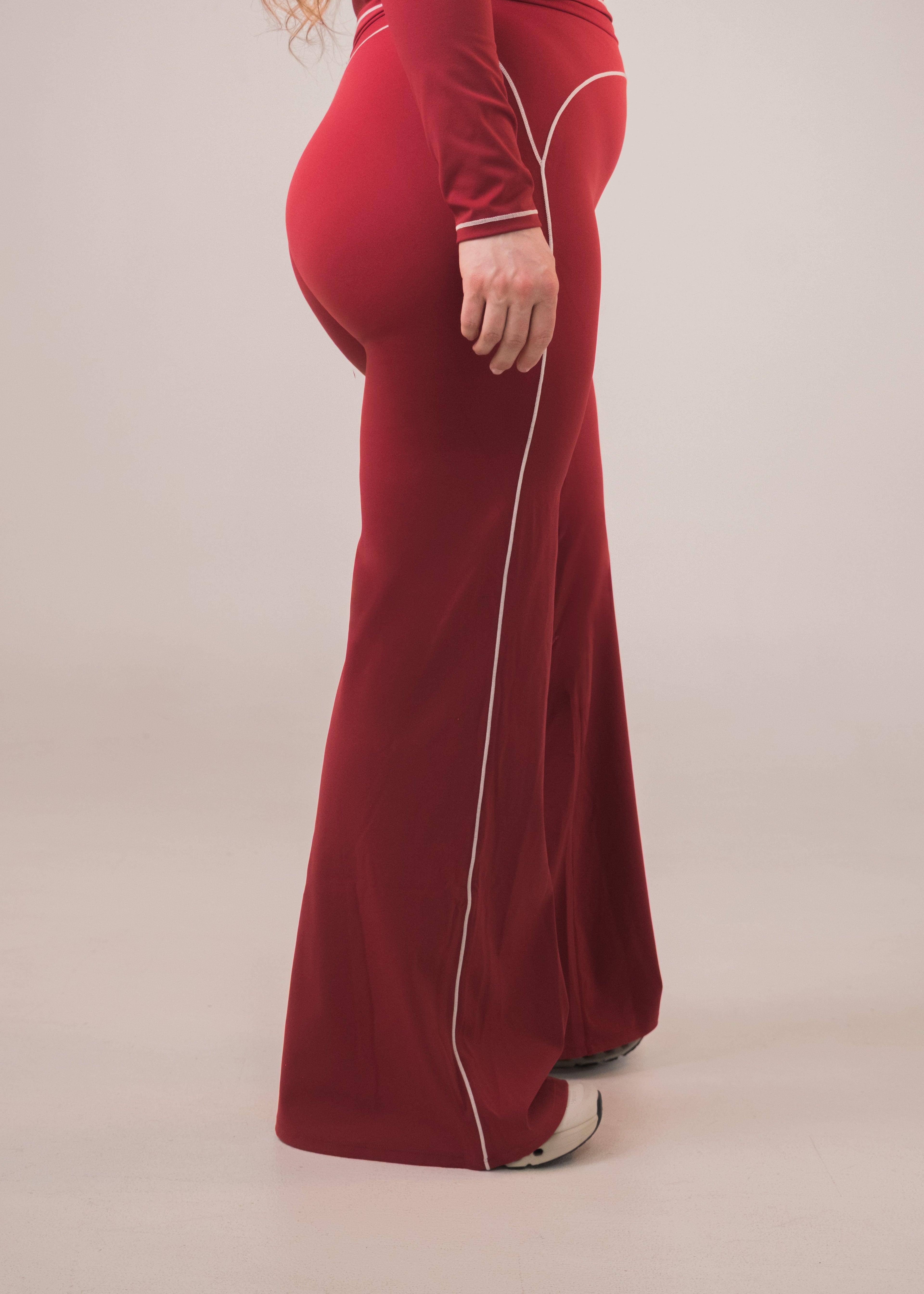 Red velvet outfit with white piping on a beige background