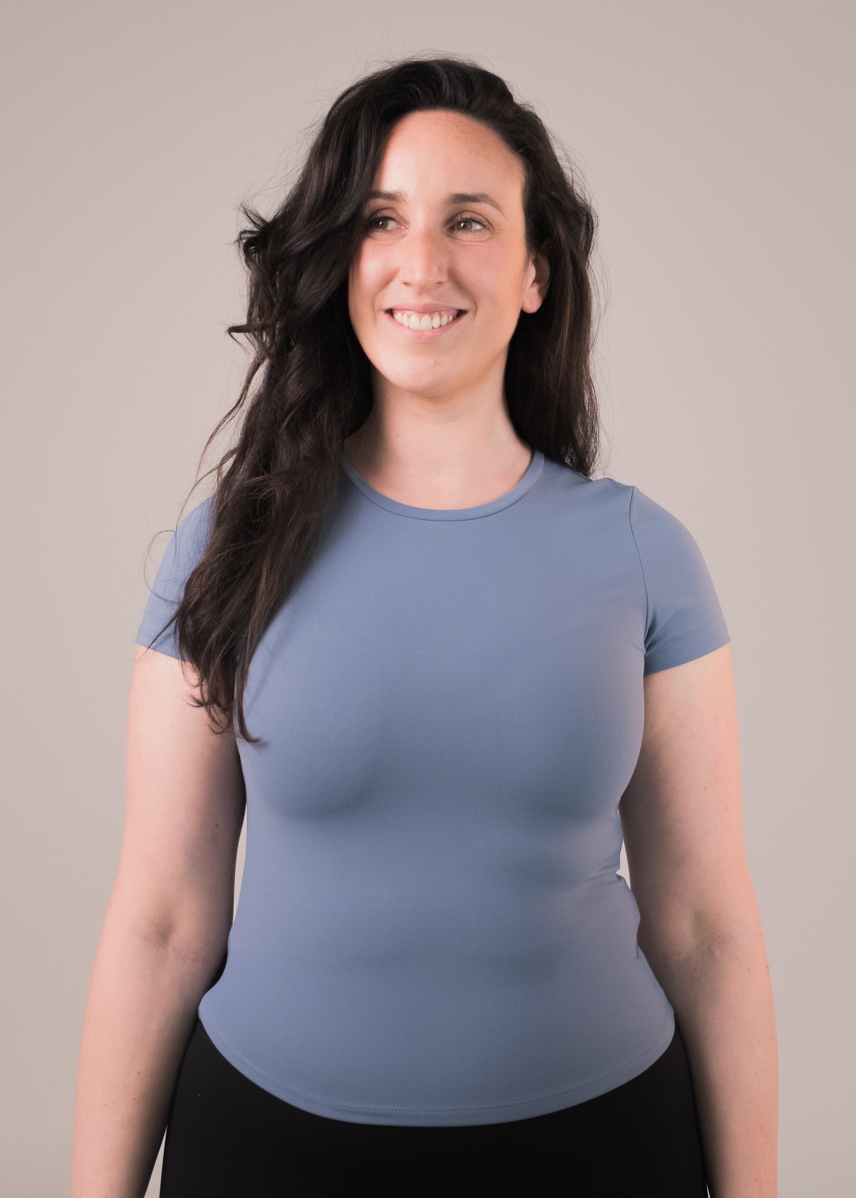 Woman wearing a light blue t-shirt against a plain background