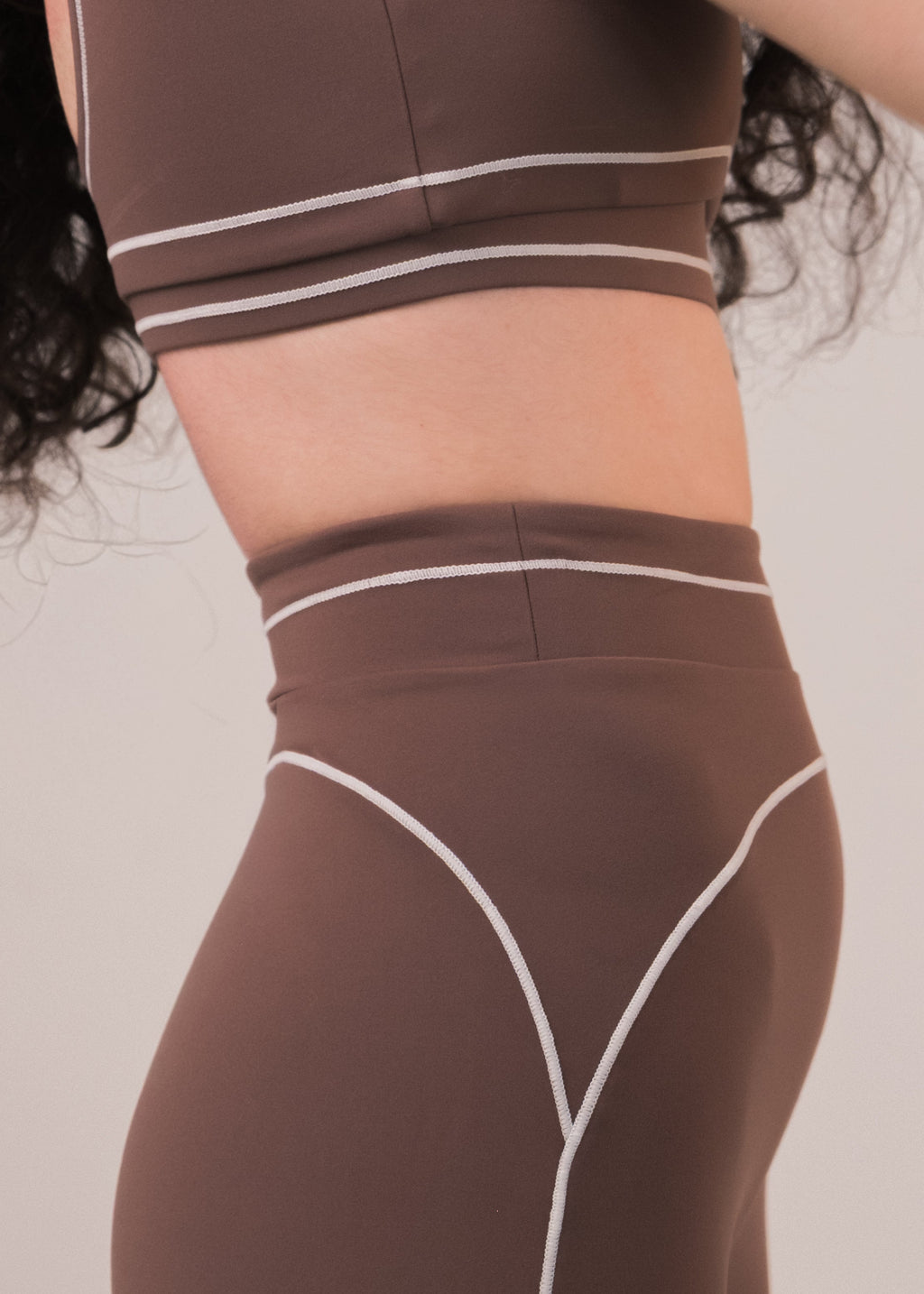 Brown athletic outfit with white accents on a plain background