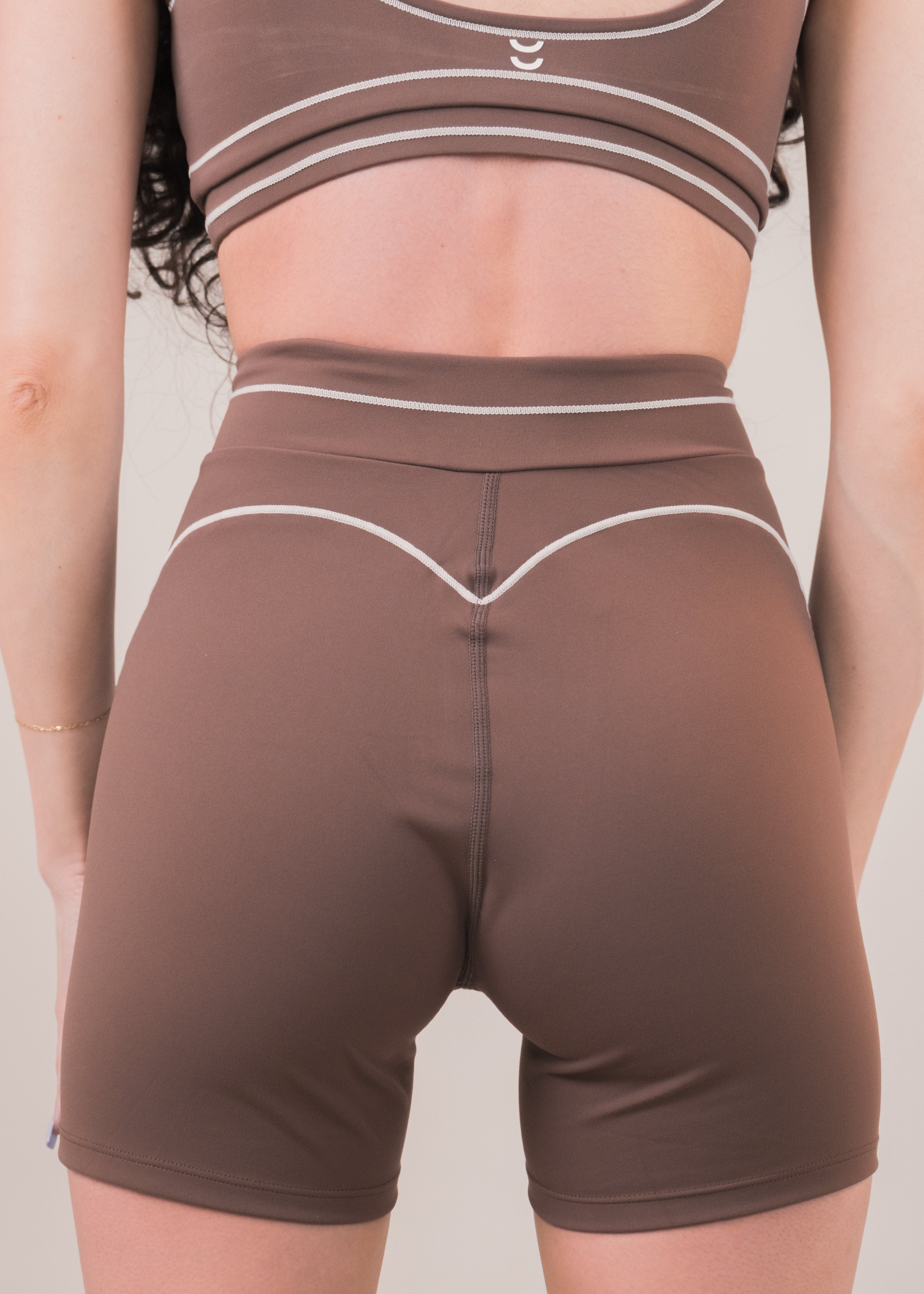 Brown athletic shorts worn by a person on a plain background