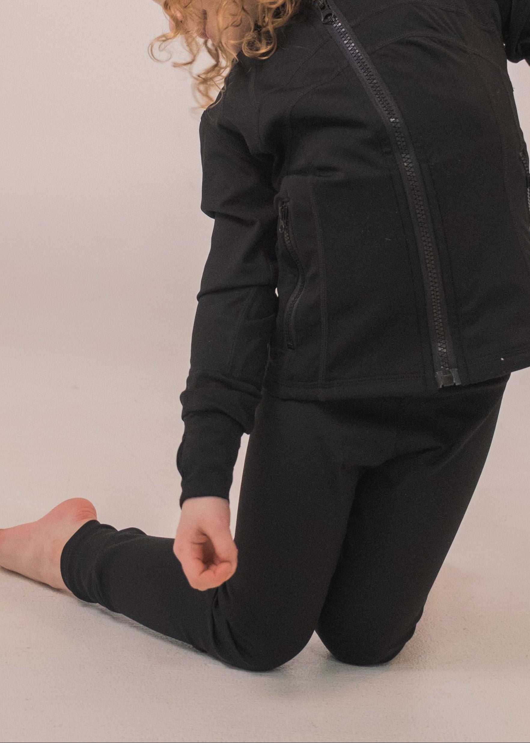 Person wearing a black outfit on a plain background