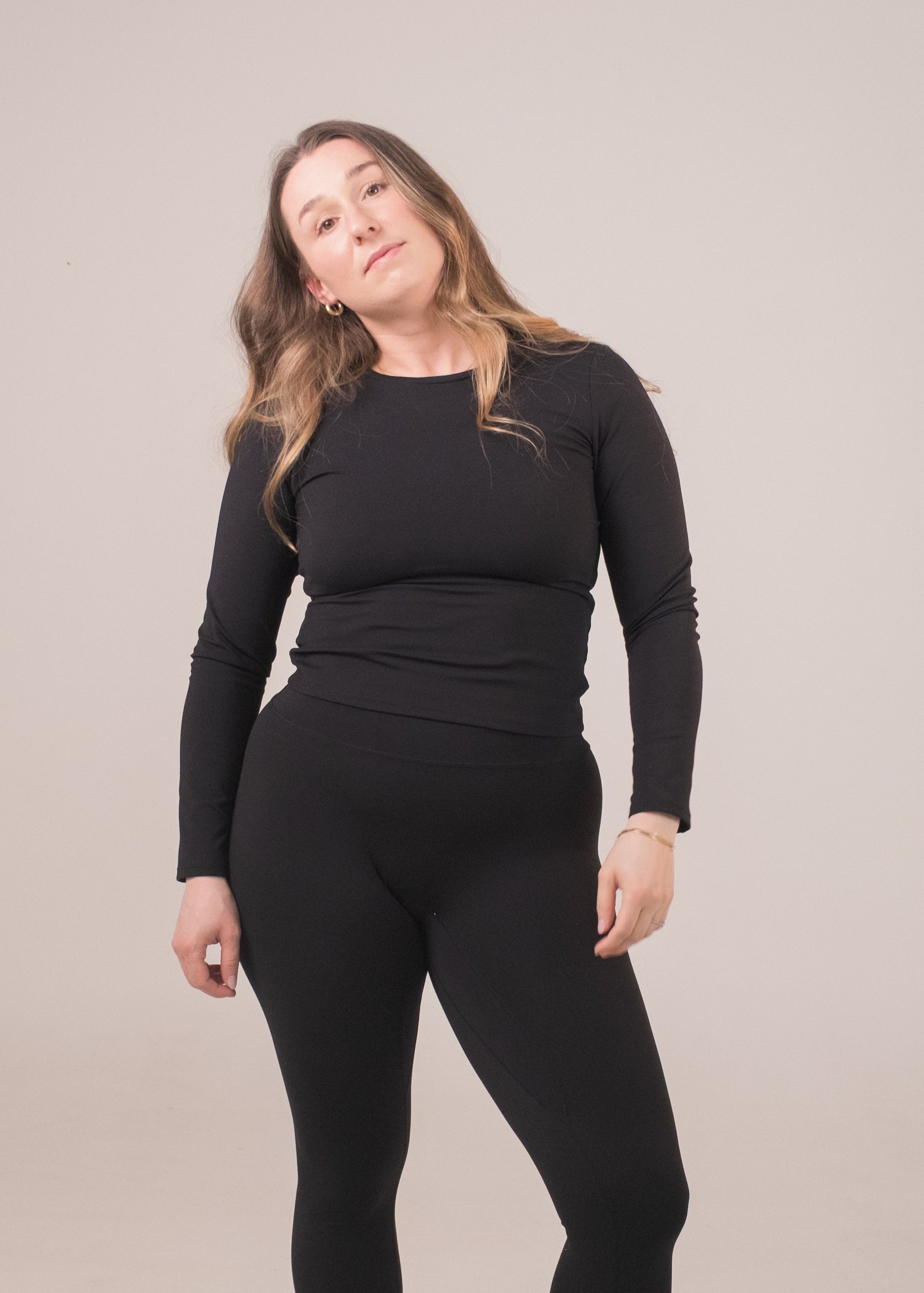 Person wearing a black outfit on a plain background