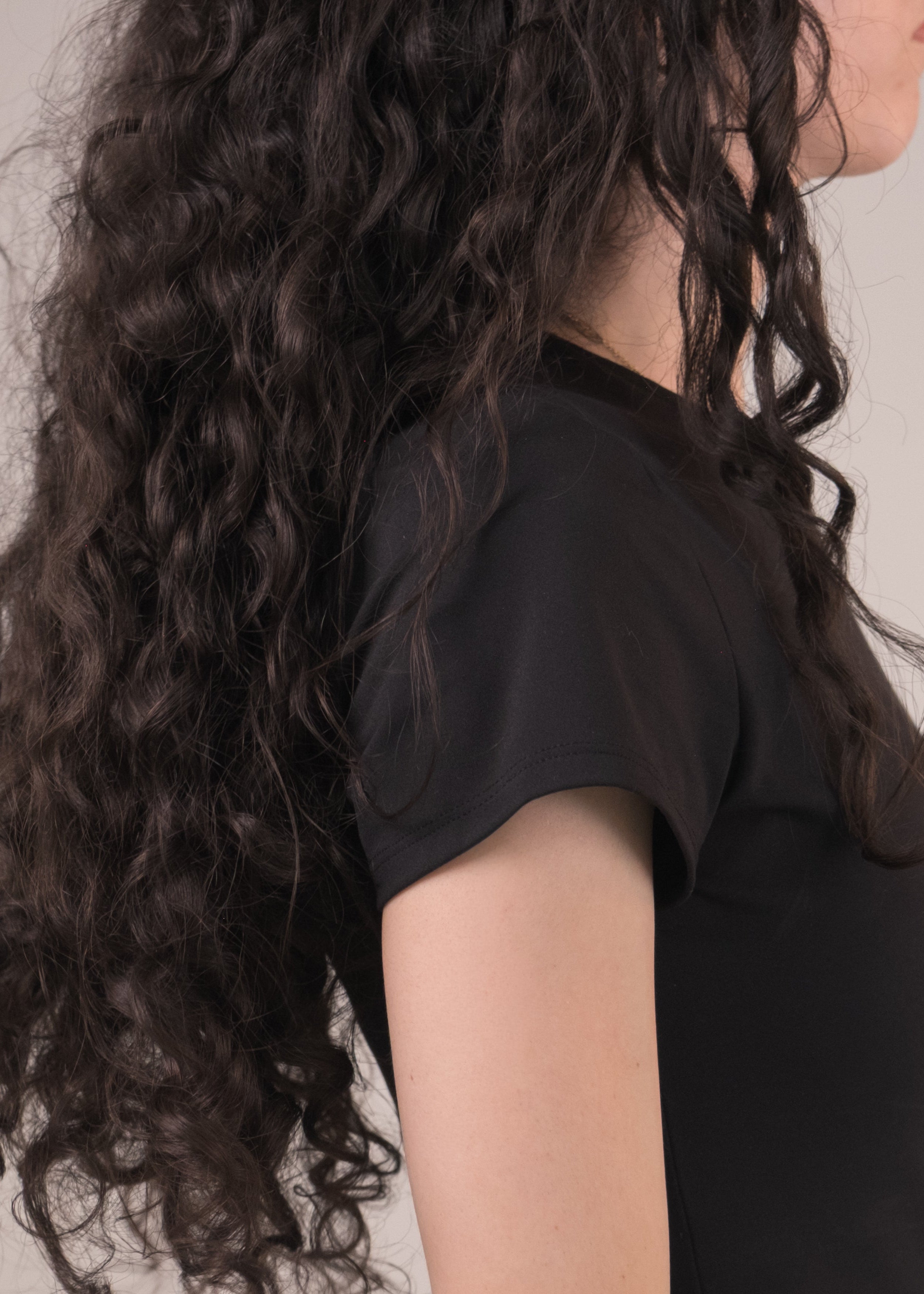 Woman wearing a black dress against a plain background