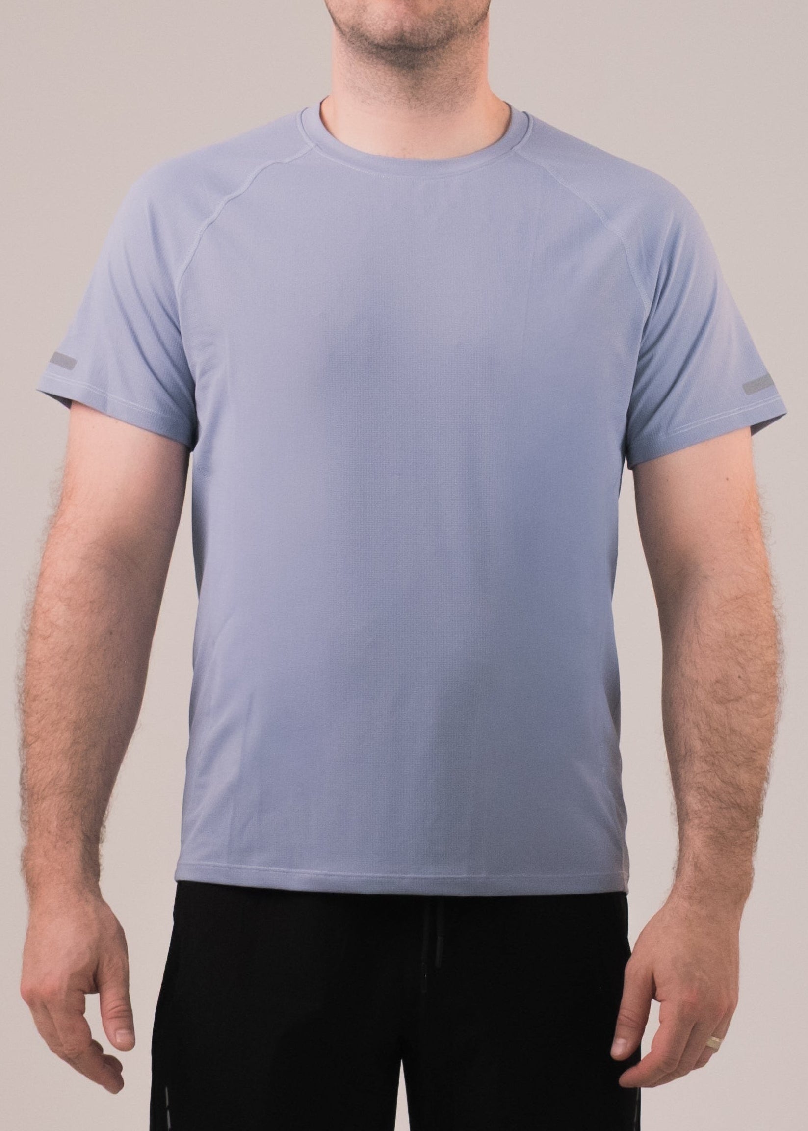 Person wearing a light blue t-shirt and black shorts on a plain background