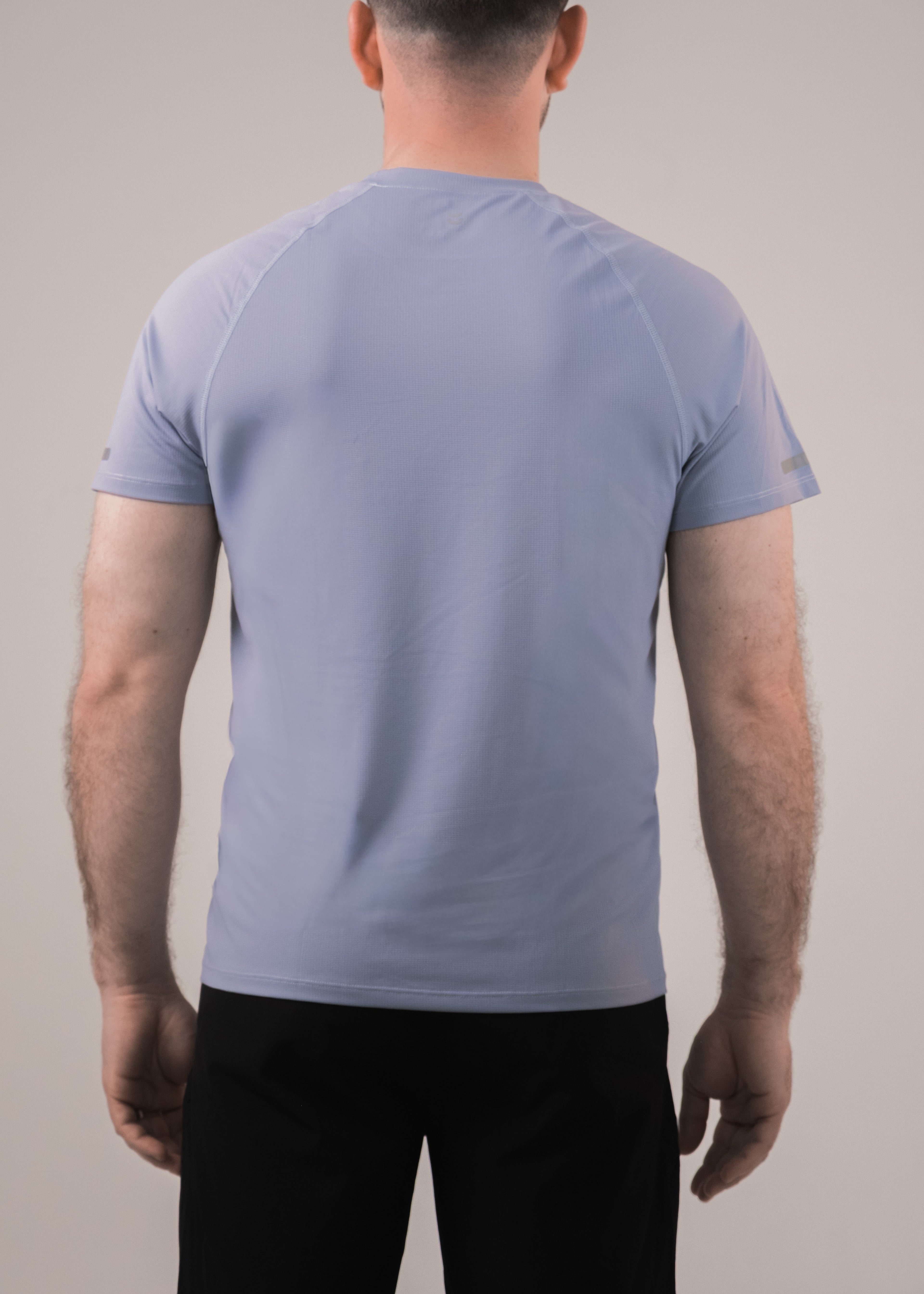 Man wearing a light blue t-shirt on a plain background