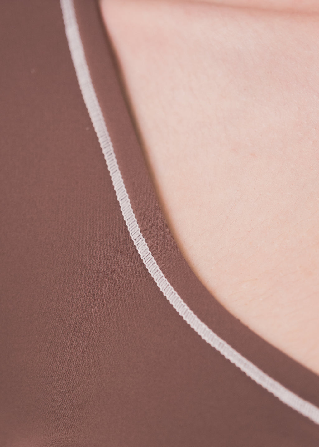 Close-up of a brown garment with a white seam detail