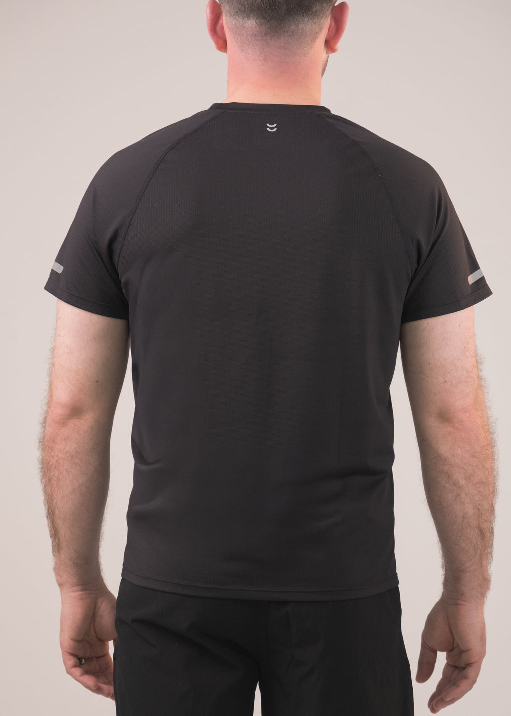 Person wearing a black t-shirt and pants on a plain background