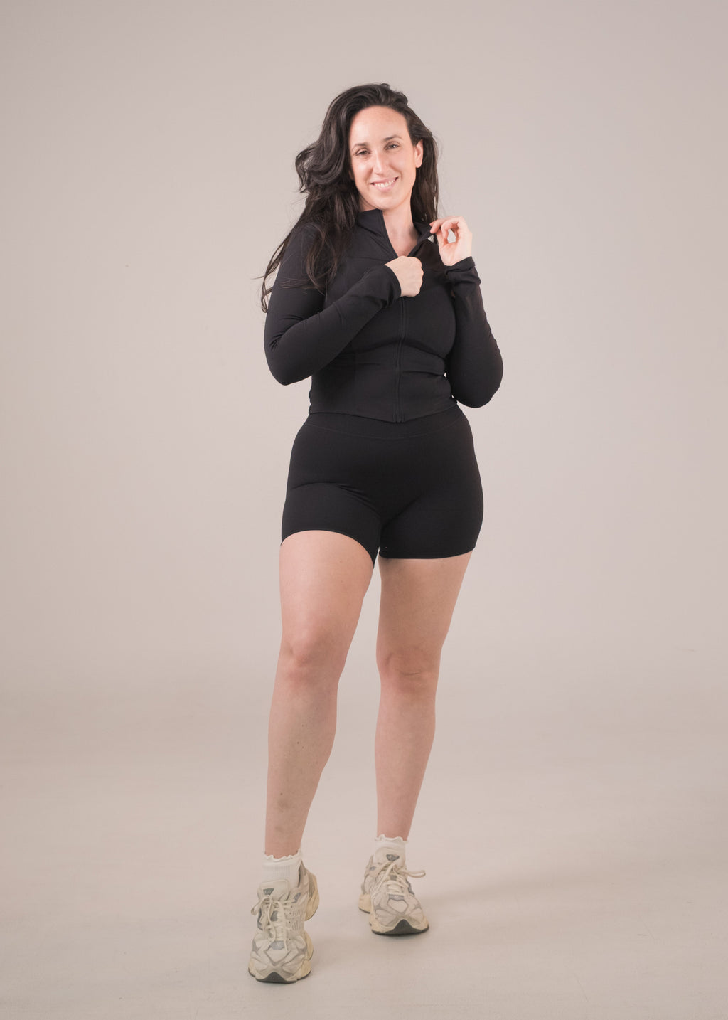 Woman wearing a black outfit on a beige background