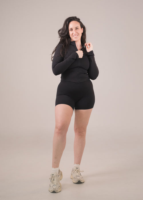 Woman wearing a black outfit on a beige background