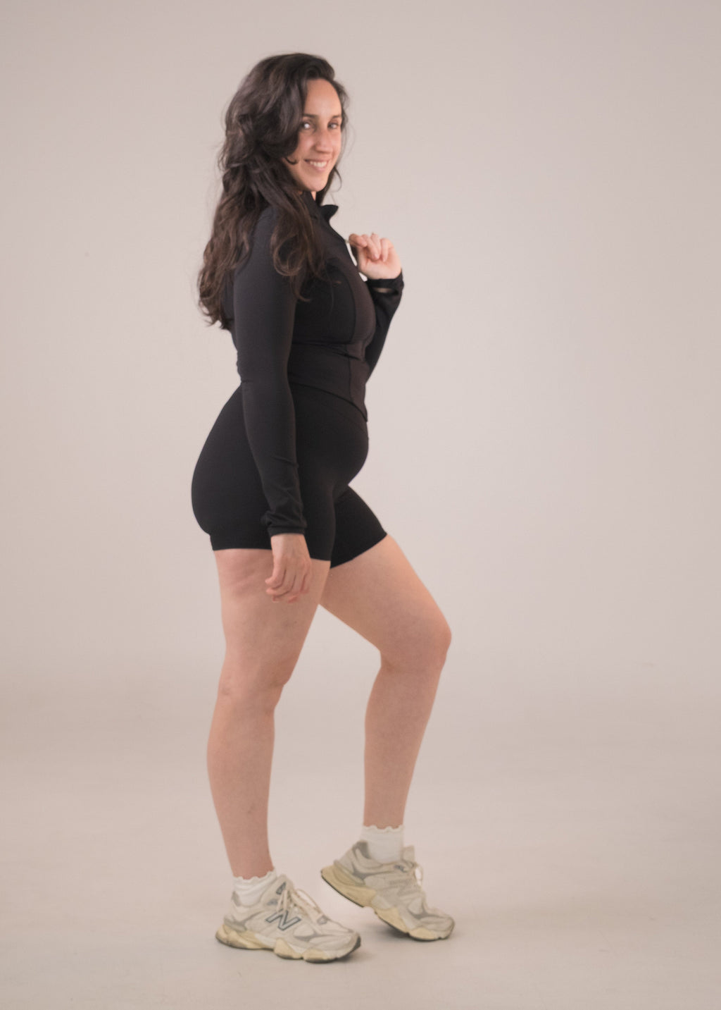 Person wearing a black outfit on a plain background