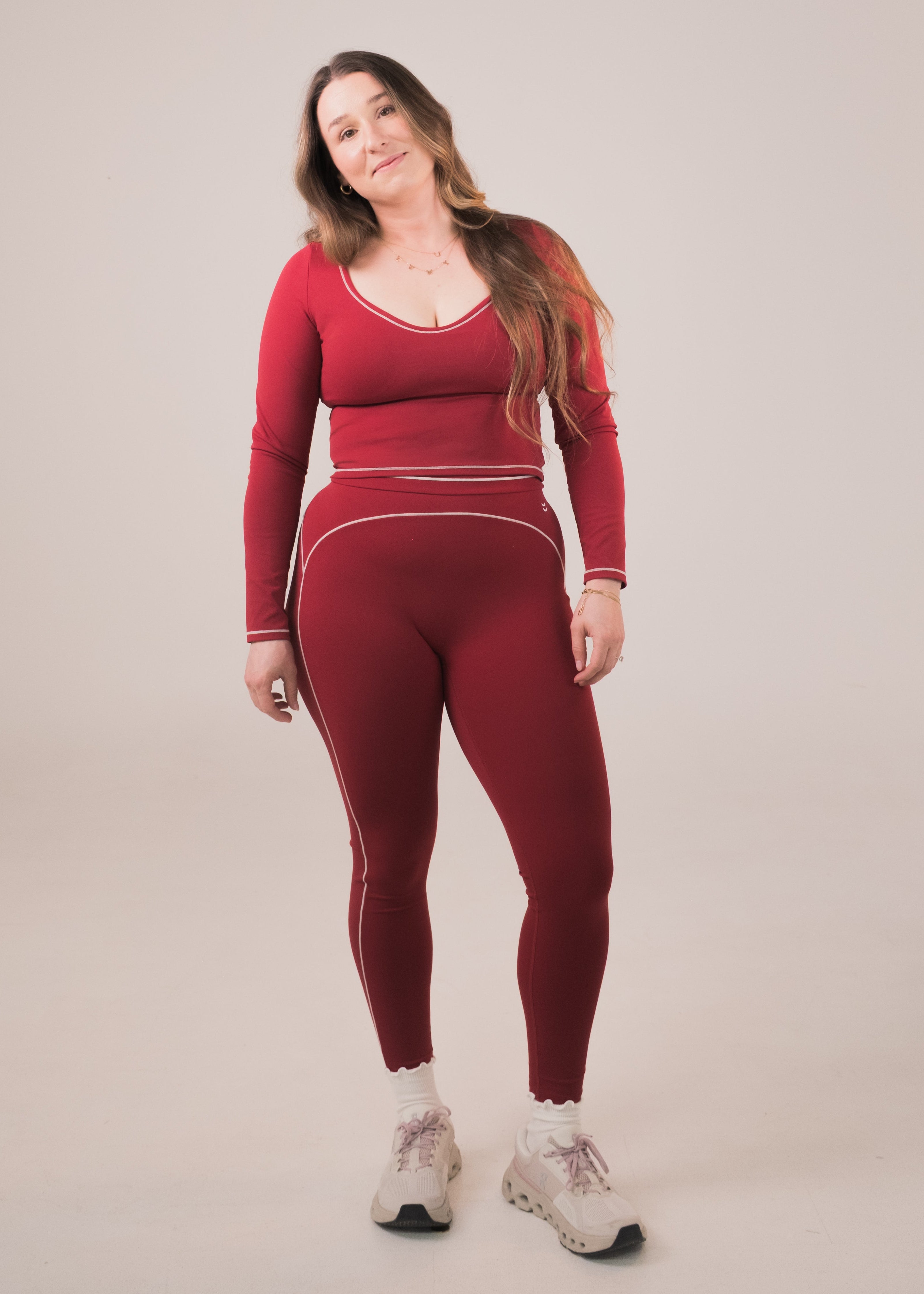 Woman wearing a red athletic outfit on a plain background