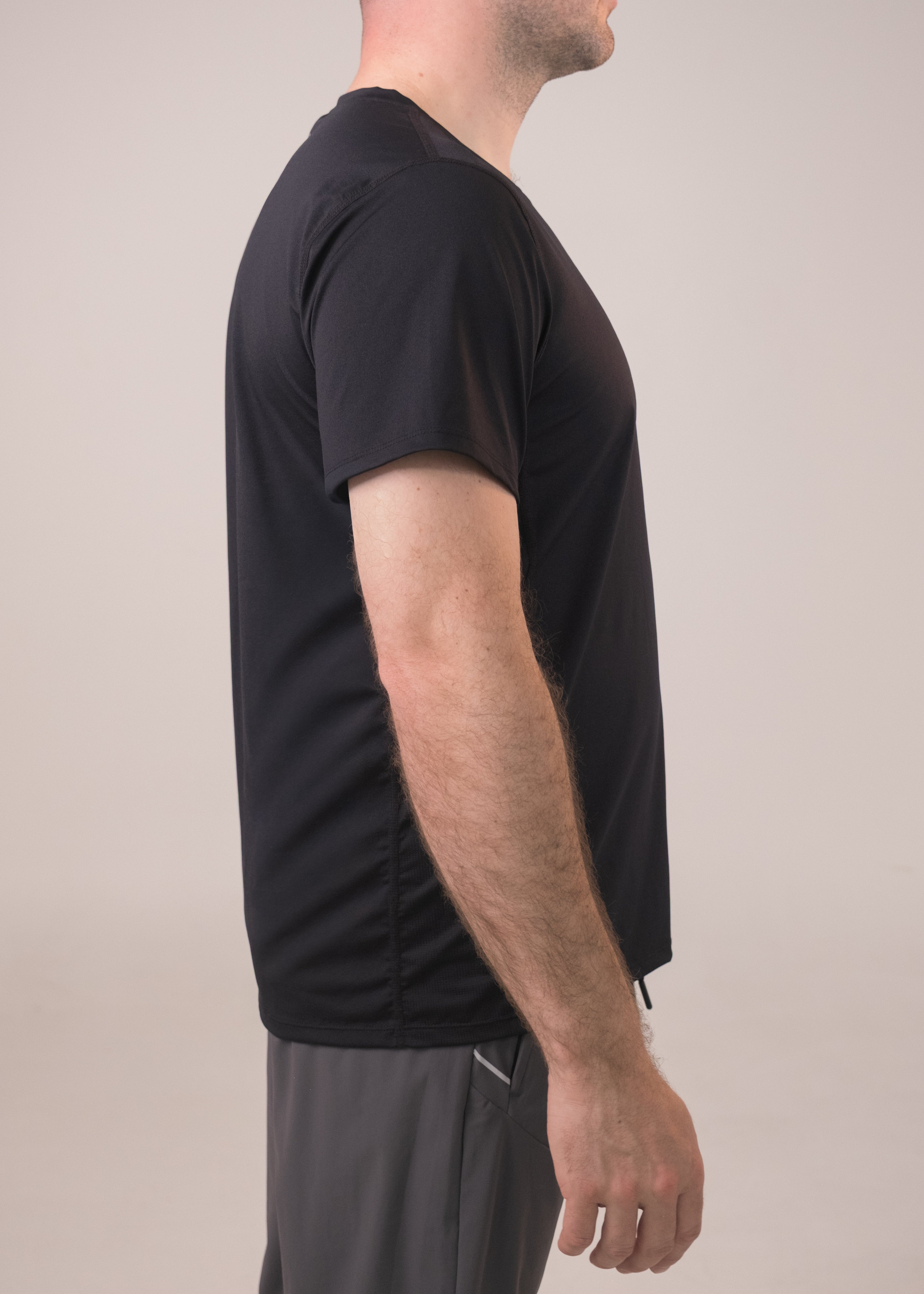 Person wearing a black t-shirt and gray shorts against a plain background