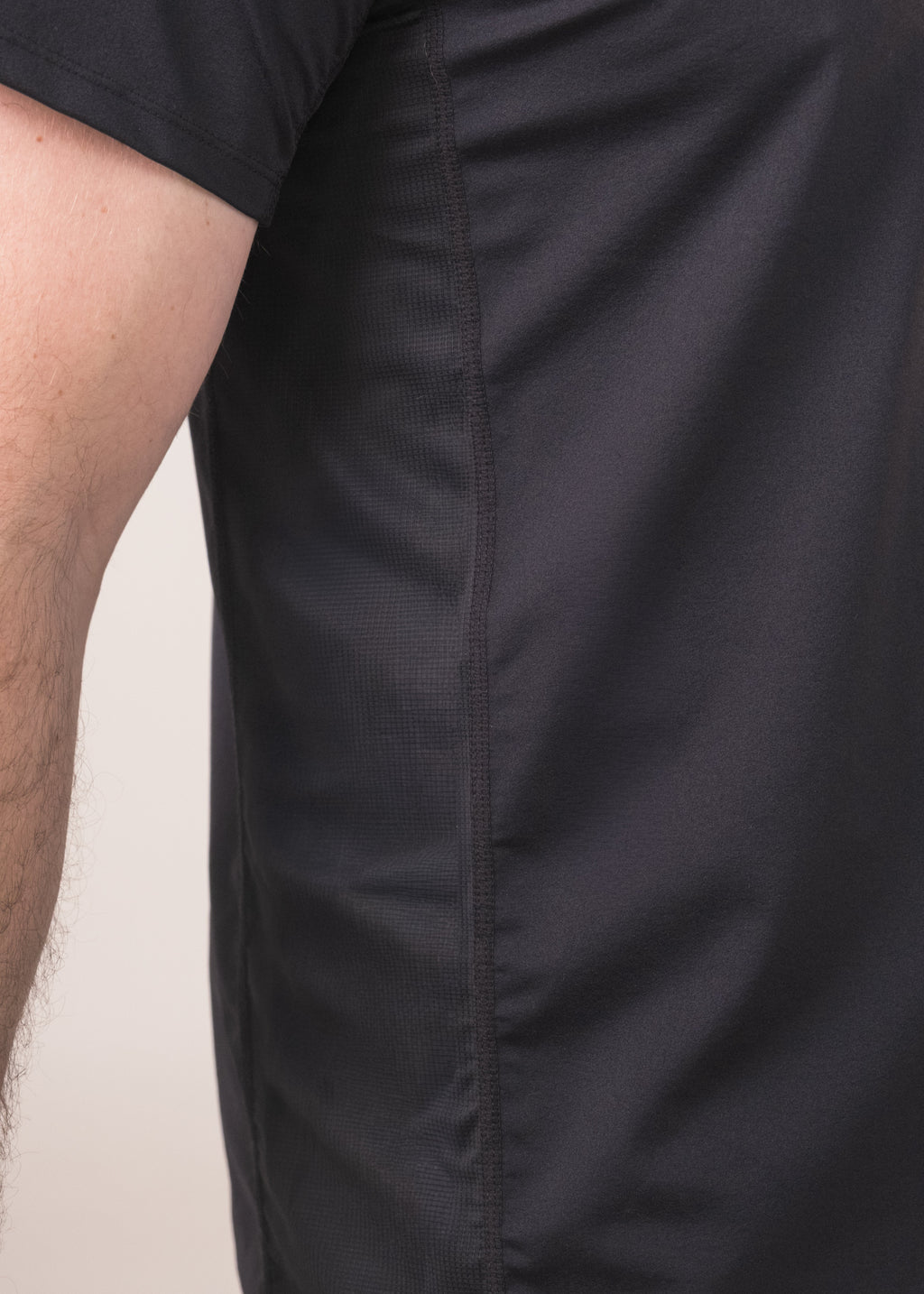 Close-up of a person wearing a black shirt with a plain background