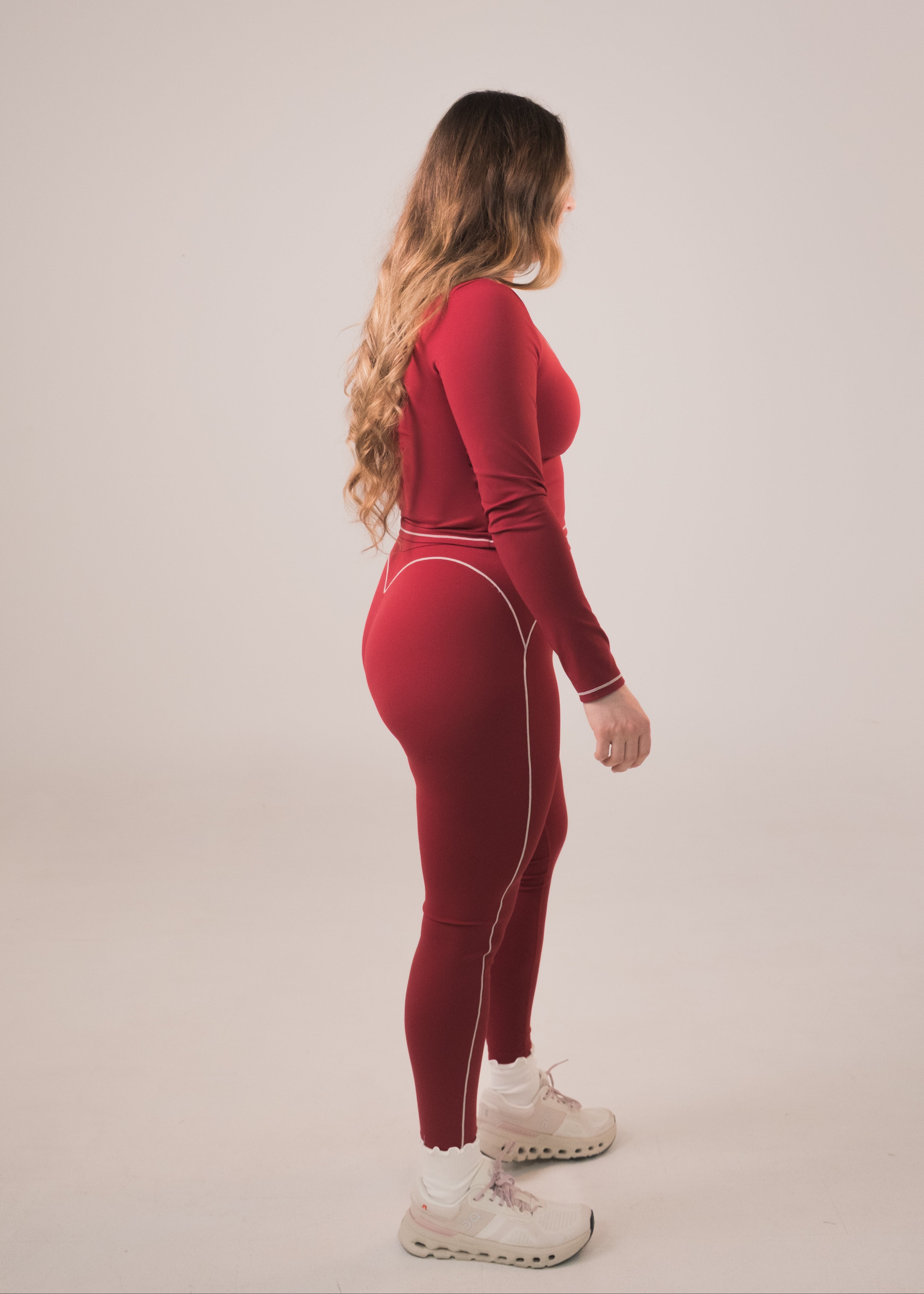Person wearing a red outfit with white accents on a plain background