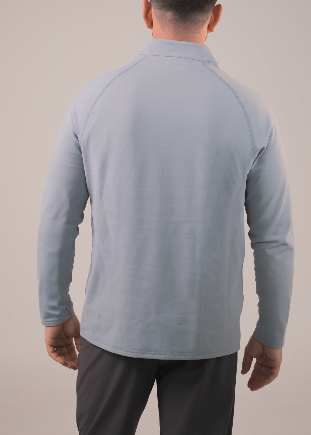Man wearing a light blue long-sleeve shirt against a plain background