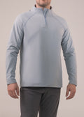 Man wearing a light blue pullover with a zipper on a plain background