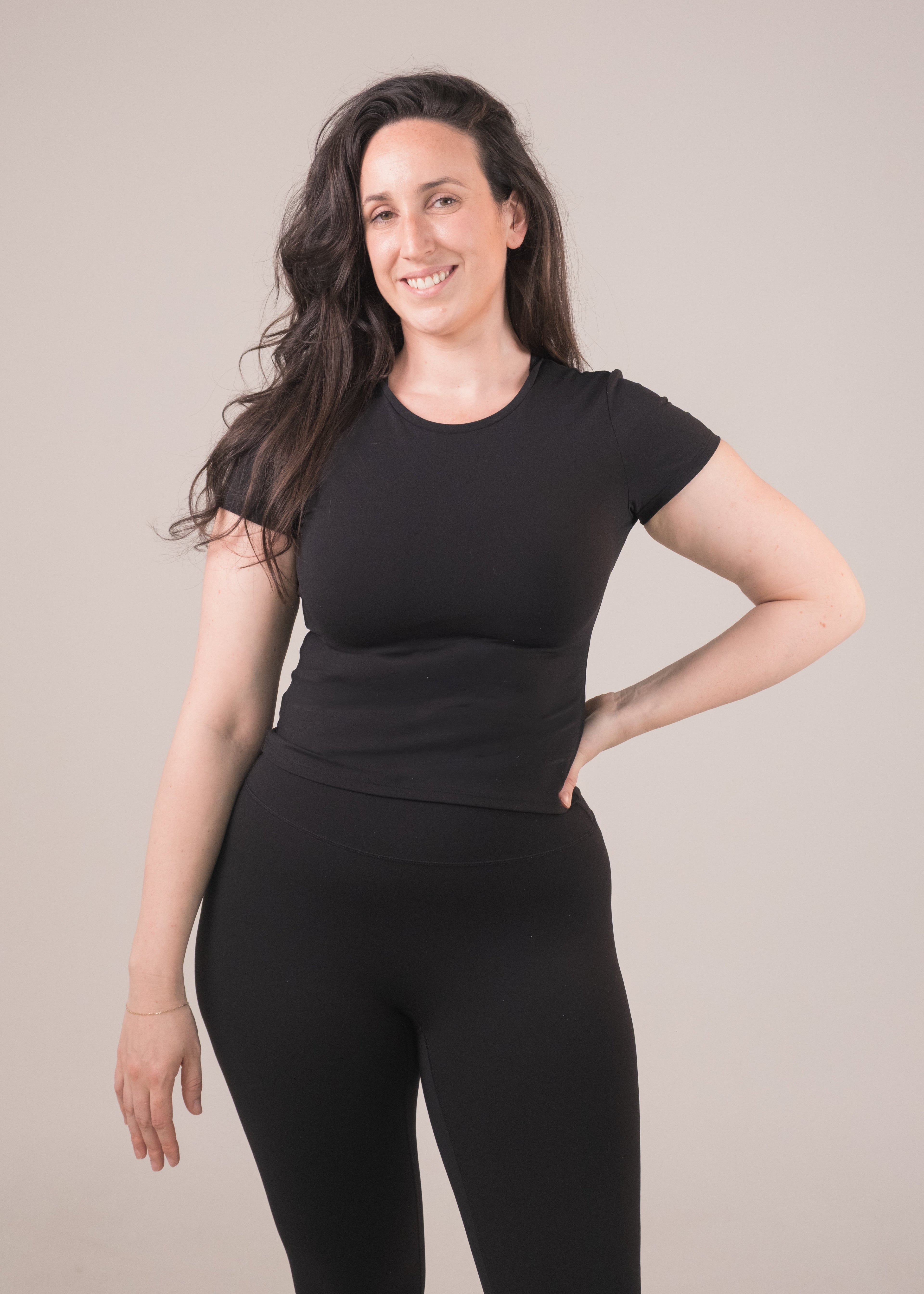 Woman wearing a black outfit against a plain background
