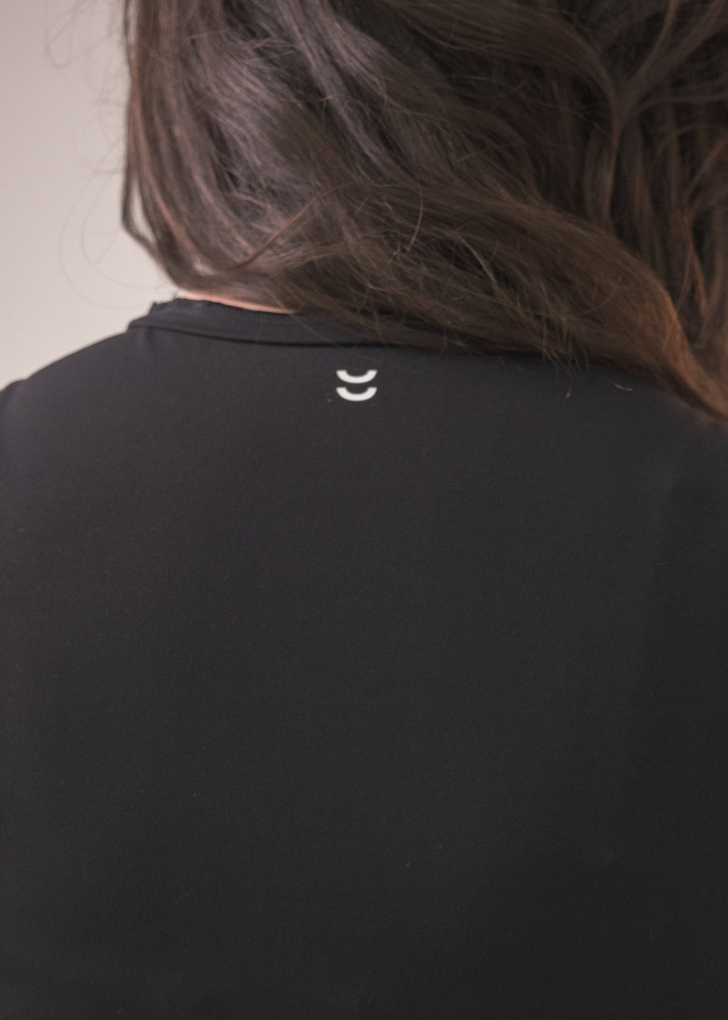 Black sleeveless top worn by a person with a neutral background
