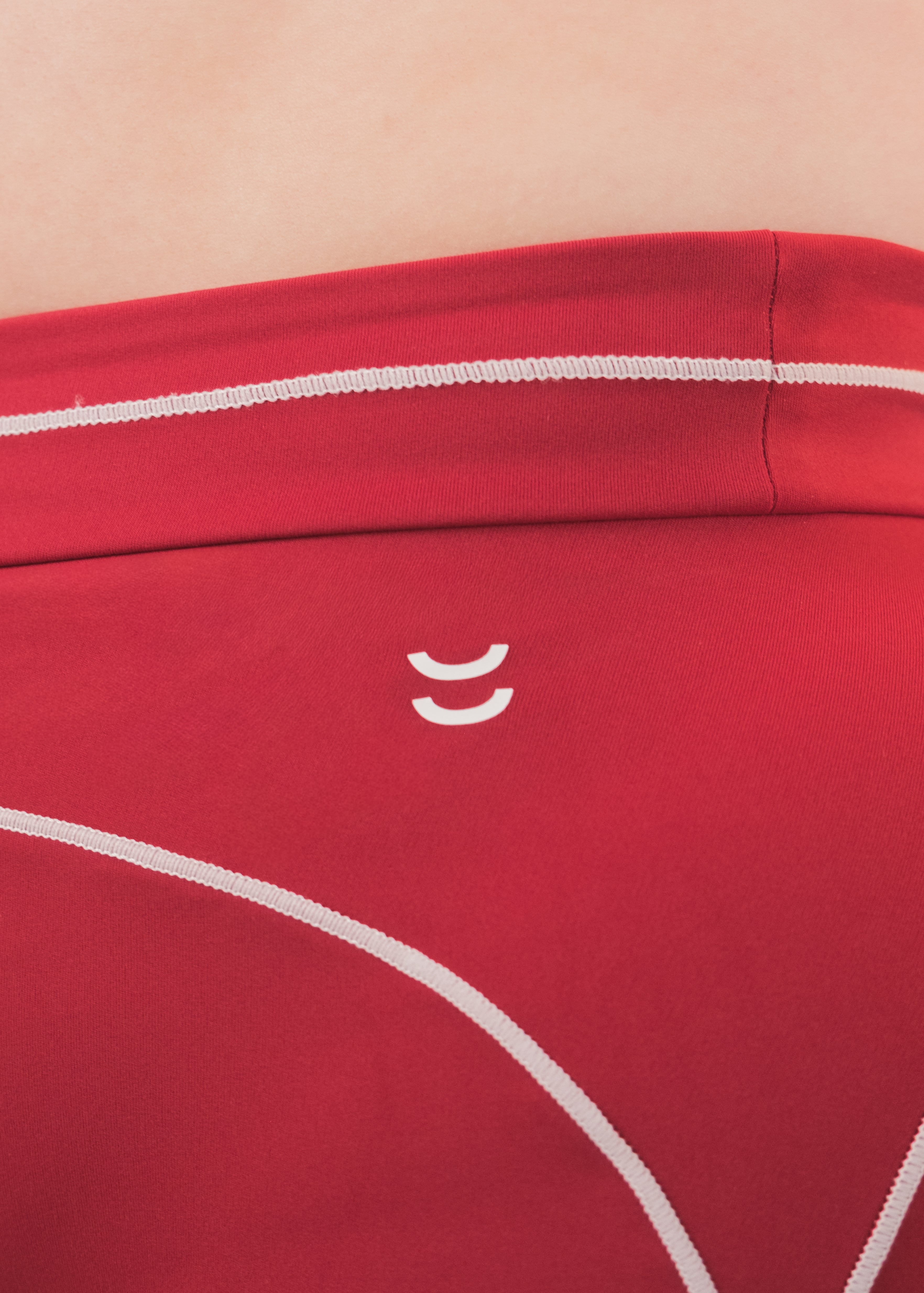 Red strapless top with white accents on a beige background