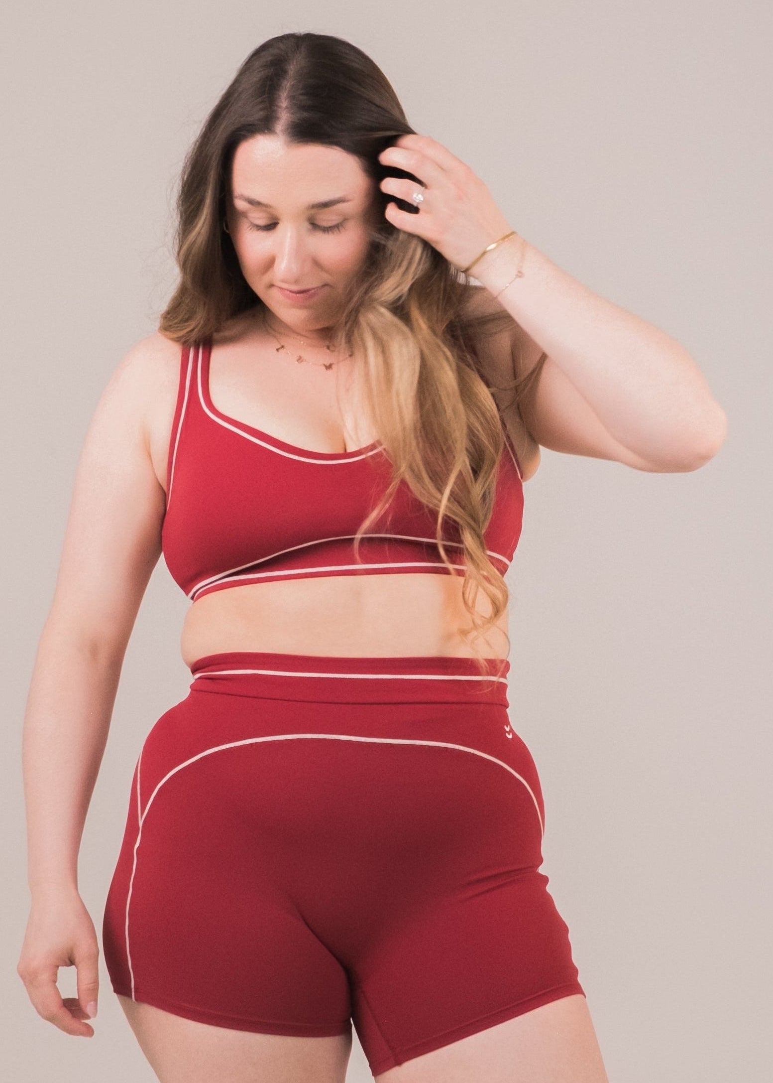 Woman wearing a red athletic outfit against a plain background