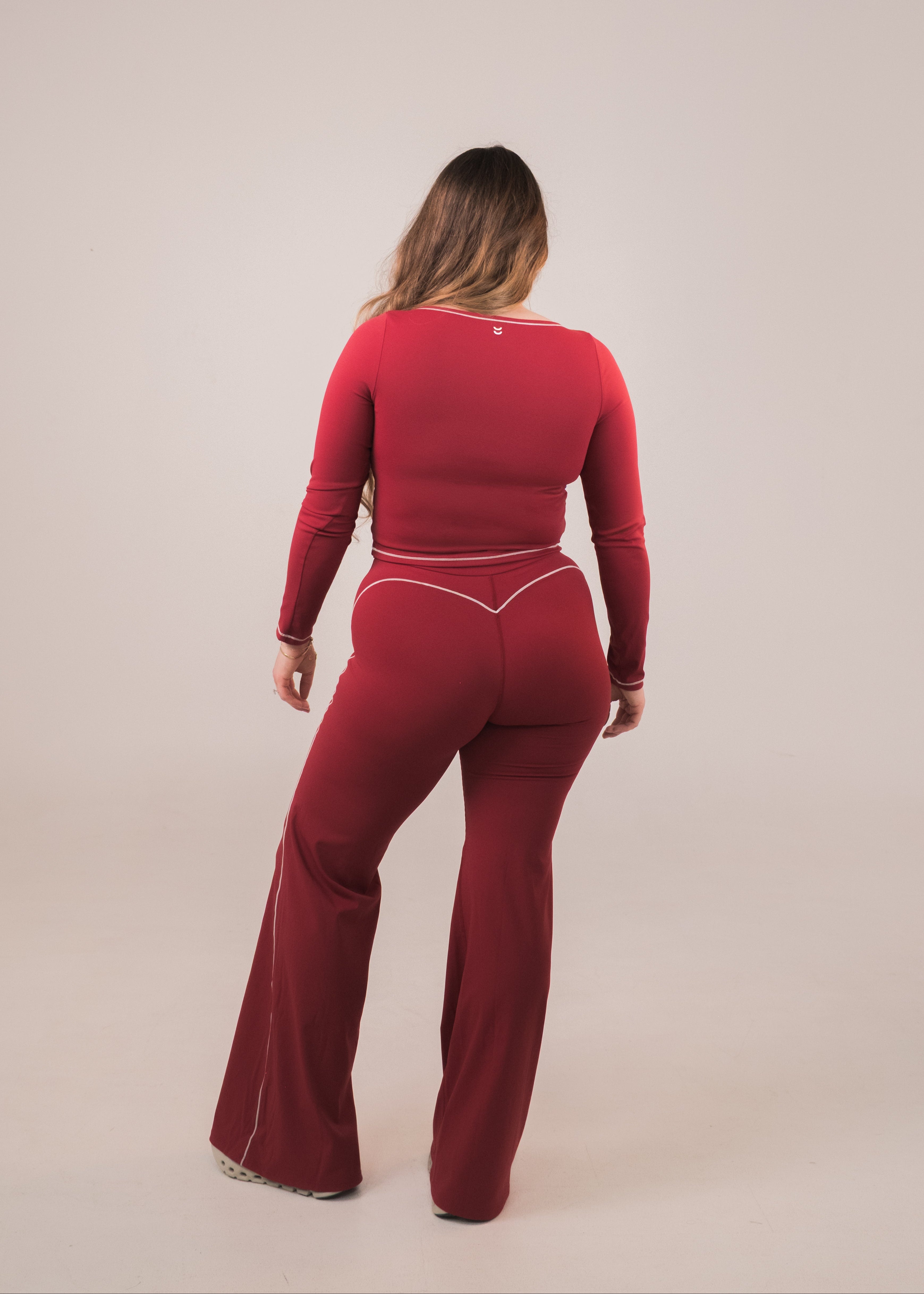 Person wearing a red outfit on a beige background